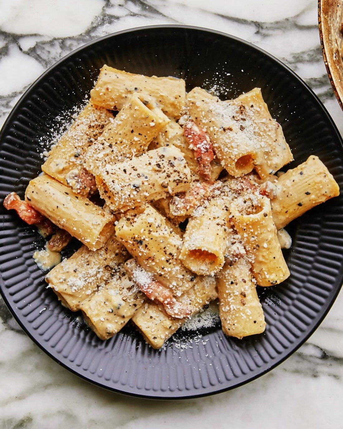 The cool thing about releasing a new video on our YouTube channel that features carbonara, is that we get a new carbonara recipe out of it! It's from @lallimusic and it's got less pasta than a classic version, more crispy-chewy strips of guanciale, and more silky creamy egg to hold it all together. Head to the link in our profile for both the recipe and the video it's featured in. 📸: @emmafishman food styling: @mpearljones
